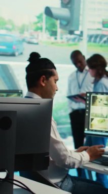 Dikey Video Hintli çalışan gözlem odasındaki uydu haritası yönlerini bildiriyor, CCTV güvenlik sistemi üzerinden şehrin etrafındaki trafiği izliyor. Genç adam video izleme verileriyle çalışıyor.
