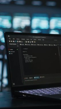 Veri merkezinde en iyi performansı sağlamak için dizüstü bilgisayarda yazan dikey video bilişim destek çalışanı. Sunucular arasında enerji tüketimini izleyen işçilerin kullandığı dizüstü bilgisayarın yakın plan görüntüsü