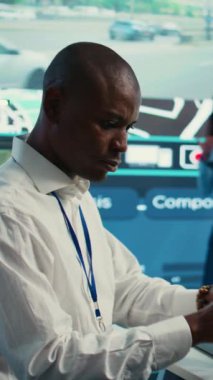 Dikey Video Afrikalı Amerikalı sevkiyat operatörü uydu haritasındaki emirlere uyarak teslimat kamyonu şoförüne koordinatları ve koordinatları verir. Çalışan trafiği izler