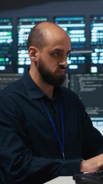 Verileri hackerlardan korumak için yüksek teknoloji sunucu merkezindeki bilgisayar kullanan dikey video teknisyeni. Bıçak sunucularını izinsiz erişime karşı koruyan mühendis, sistemi...