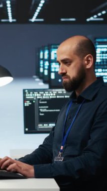 Dikey video sistemi yöneticisi sunucu odasını denetliyor, PC 'de kod çalıştırıyor, sorun yaratıyor. Donanım kümelerini, ağ sistemlerini ve depolama dizilerini yükselten yazılım uzmanı, çekimler