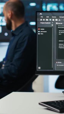 Farklı iş yükleri için bilgisayar kaynakları sağlayan sunucu satırlarıyla birlikte yüksek teknolojili bir tesiste dikey bilgisayar bilimci programlama. Bilişim programcısı süper bilgisayarları denetliyor.