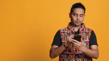 Hintli adam cep telefonu sitesine ödeme metodu ekliyor, bir şeyler satın alıyor, stüdyo arka planında izole edilmiş. Müşteri internet alışverişi yapıyor, cep telefonu ve kamera A 'da banka kartı bilgileri yazıyor.