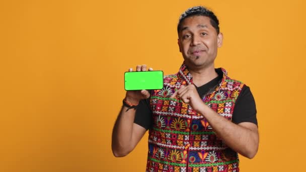 Leende Indian Man Presenterar Mobiltelefon Med Grön Skärm Display Isolerade — Stockvideo
