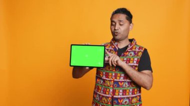 Stüdyo arka planında izole edilmiş yeşil ekran tableti kullanarak Hintli bir adamın portresi pazarlama yapıyor. Gülen kişi elinde boş kopya alanı düzeneği, kamera B