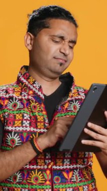 Tablet üzerinden bir şeyler satın almaya çalışırken gerekli paradan mahrum kalan dikey video adam üzgün. Bankamatik işlemleri cihazda reddedildikten sonra üzgün kişi kart bakıyor, stüdyo arka planı