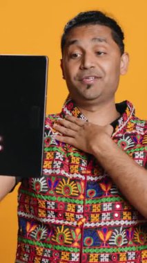 Dikey video Radiant, arkadaşınızı selamlıyor, arkadaşça jestler yapıyor. Telekonferansta arkadaş ile iletişim kuran neşeli kişi tablet, stüdyo arka planı, kamera A