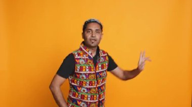 Geleneksel Hint kıyafetleri giymiş kendinden geçmiş bir insan enerjik dans adımları atıyor. Bollywood koreografisi hareketleri, stüdyo geçmişi, kamera B...