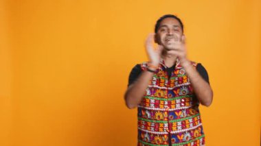 Neşeli Hintli adam el çırpmaktan mutlu, başarılardan mest olmuş. Heyecanlı insan iyi habere tepki veriyor, tezahürat yapıyor, alkışlıyor, stüdyo arka planında izole edilmiş, kamera B