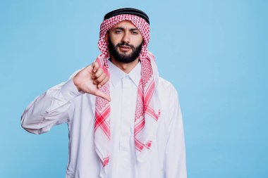 Geleneksel Arap kıyafetleri giymiş Müslüman bir adam stüdyo portresini gösteriyor. Tobe ve Gutra 'lı Araplar fikir ayrılıklarını gösteriyor ve kameraya ciddi bir ifadeyle bakıyor.