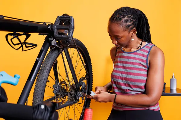 Skilled African American Lady Repairs Bicycle Adjusting Inspecting Its Components — стоковое фото