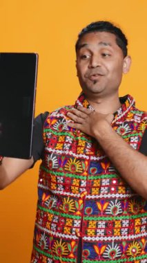 Dikey video Radiant, arkadaşınızı selamlıyor, arkadaşça jestler yapıyor. Telekonferansta arkadaş ile iletişim kuran neşeli kişi tablet, stüdyo arka planı, kamera B