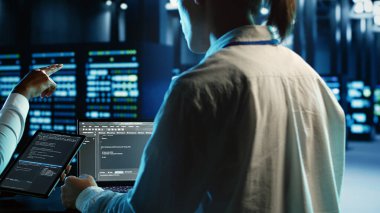 Tablet ve dizüstü bilgisayarda kod çalıştıran mühendislik ekibi üyeleri, sunucu kuleleri, ağ sistemleri ve depolama dizileri için tasarlanmış profesyonel veri merkezi ekipmanlarını güncelliyor