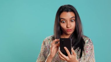 Mutlu bir kadın telefonda en iyi arkadaşıyla sohbet ediyor, dinlenme zamanının tadını çıkarıyor. Arkadaşla telefon kullanarak iletişim kuran neşeli kişi, stüdyo arka planında izole edilmiş, kamera B