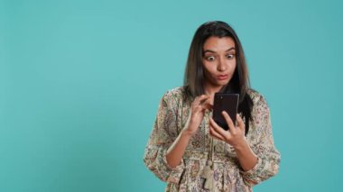 Mutlu bir kadın telefonda en iyi arkadaşıyla sohbet ediyor, dinlenme zamanının tadını çıkarıyor. Arkadaşla telefon kullanarak iletişim kuran neşeli kişi, stüdyo arka planında izole edilmiş, kamera B