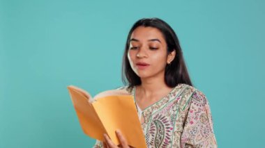 İlginç kitaplar okuyan, hobiden hoşlanan, eğlenen, stüdyoda izole edilmiş biri. Kollarında romanı olan neşeli bir kadın gevşeme zamanının tadını çıkarıyor, sesli kitap okuyor, kamera B