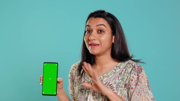Mulher Apresentando Telefone Celular Tela Verde Isolado Sobre Fundo Estúdio — Vídeo de Stock