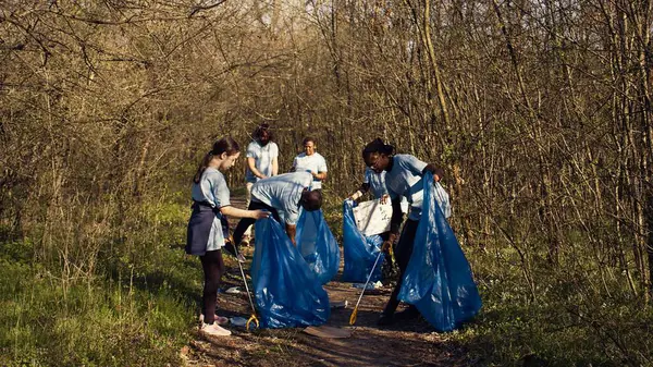 Ormanı çöpten temizlemeye çalışan bir grup gönüllü çöp ve plastik atık topluyor. Çöpleri toplayan ve geri dönüşüm yapan çevreciler ekolojik adaleti destekliyor. Kamera B.