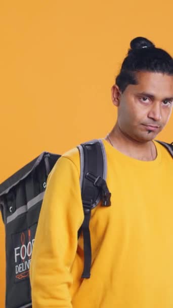 Portret Uśmiechniętego Indiańskiego Motocyklisty Trzymającego Termalny Plecak Odizolowany Tle Studia — Wideo stockowe