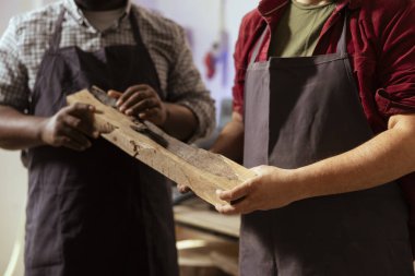 Üretici ve çırak yüksek kalitede ahşap malzemeler seçerek proje gereksinimlerini karşılamalarını sağlıyor. Dolap yapımcısı ve meslektaşı kereste parçası için kalite güvencesi veriyor. Yakın çekim.