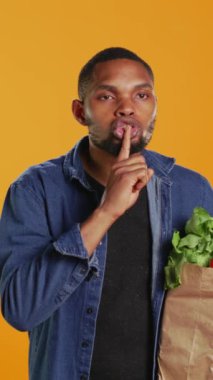 Dikey Video Genç Yetişkin, yeni toplanan etik kaynaklı ürünler hakkında sır olarak tutmak için sessiz bir sembol gösteriyor. Market alışverişi yapan bir erkek özel hayatı yaşıyor. Kamera B.