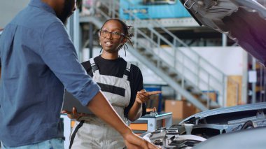 Araç servisindeki mühendis, arızaları düzelttikten sonra müşterinin tamir faturasını hesaplamak için dizüstü bilgisayar kullanıyor. Araç hizmet verdikten sonra son maliyetleri belirlemek için gerekli niteliklere sahip uzman kullanıcı