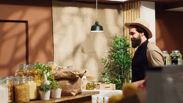 stock image Panning shot of bustling sustainable zero waste supermarket ran by zealous storekeeper. Local neighborhood store full with customers shopping for organic eco friendly produce