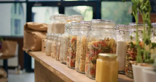 Close up on bulk products in reusable jars used by zero waste eco store to eliminate single use plastics, sustainable lifestyle. Local organic shop storing pantry supplies in nonpolluting packaging.