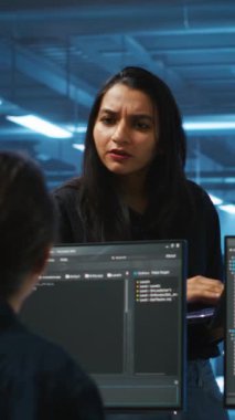 Sunucu merkezindeki dikey video denetleyicisi ekipman düzensizliği arayan çok ırklı programcıları yönetiyor. Veri merkezinin hasar tespiti için teknik uzmanları koordine eden yönetici