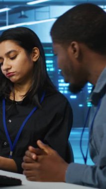 Veri merkezindeki dikey video çalışanları yıllık sistem inceleme belgelerine bakıyor, parametreler hakkında tartışıyorlar. Yüksek teknolojili çalışma alanında beyin fırtınası yapan meslektaşlar sunucu kümeleri hakkında konuşuyorlar.