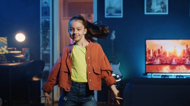 Popüler hit şarkıları dinlerken sosyal medya platformları için viral dans yapan mutlu çocuk. Gülümseyen çocuk en son viral müzikte takipçileri için dans videosu kaydediyor.