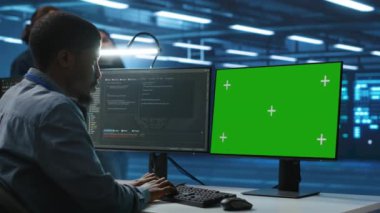 Bilgi işlem uzmanı, yeşil ekran PC kullanarak tehditlerden korunan değerli verileri sağlıyor. İzinsiz giriş ve savunmasızlıklara karşı donanımları koruyan bir adam.