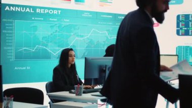 Finans müdürü ekip üyelerine yeni şirket hedefleri hakkında brifing vererek bütçe planlarını harcamalarla sunuyor. Kaynak tahsisi ve proje planlaması kontrol odasında. Kamera A.
