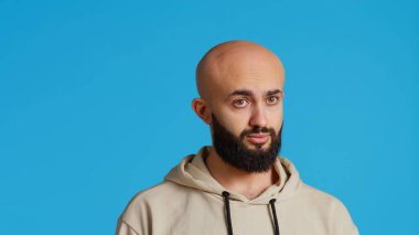 Arap biri parmaklarıyla negatif işaret veriyor, kameranın önünde reddediyor. Ortadoğulu adamın stüdyoda bir sembolü yok. Reddetme ve yasaklama jesti yapıyor. Kamera 2.