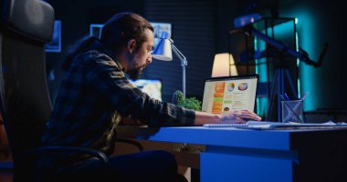 Şirket projesi için verileri araştırırken dizüstü bilgisayardaki istatistiksel veri finans grafikleriyle ilgilenen adam. Serbest Çalışan mutsuz iş grafikleri, stresli hissetme, kamera B