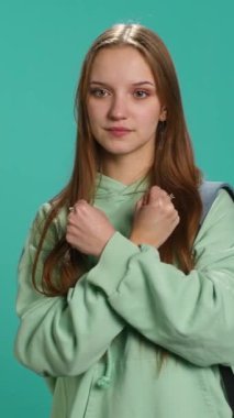 Dikey video kasetteki kadın X harfini kollarını kavuşturmuş, savaşçı duruşu sergiliyor, sertliğini gösteriyor. Reddedilme sinyali vermek için negatif vücut dili kullanan sert genç kişi, stüdyo geçmişi