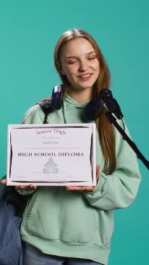 Dikey video çok sevinçli öğrenci başarıyı kutluyor, diplomasını tutuyor, mikrofonu konuşma yapmak için kullanıyor, stüdyo geçmişi. Okulu bitirdikten sonra mikrofonu iş arkadaşlarıyla paylaşmak için kullanan bir kadın.