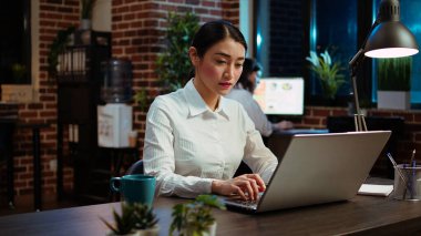 Şirket muhasebecisinin dizüstü bilgisayarına finansal notlar yazmasına zum yap ve iş geliştirme planı için satış raporlarını analiz et. Proje araştırması için bilgisayarı kullanan bir ofis çalışanı