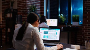 İşçi dizüstü bilgisayardaki istatistiksel veri finans grafiklerine bakarak şirket projesi için anahtar verileri araştırıyor. Borsa rakamlarını ve elektronik cihazdaki grafikleri analiz eden iş kadını, kamera A