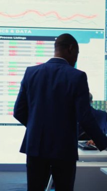 Vertical Video Corporate analistleri proje detayları ve zaman çizelgelerini inceliyor, ekip lideri rekabetçi bir ortamda iş hedeflerine ulaşmak için el ilanları ve bütçe ve operasyon planı sağlıyor