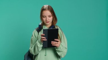 Kadın tablet dokunmatik ekranda kayıyor, sosyal medya bağlantılarını kontrol ediyor, arkadaşlara yetişiyor. Mutlu insan internet sitelerini karıştırarak rahatlıyor, stüdyo arka planında izole edilmiş, kamera A