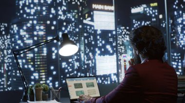 Şirket başkanının dünya çapında şirket genişletme stratejilerini değerlendirmesi, şehir merkezinin panoramasını takdir etmesi. Etkili yönetmen ilerleme için aylık kazancı analiz eder.