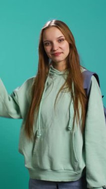 Neşeli insanın dikey video portresi boş alanı işaret ediyor, reklam yapıyor. Sunum yapan mutlu bayan, kopya metni gösteren, stüdyo arka planında izole edilmiş, kamera B