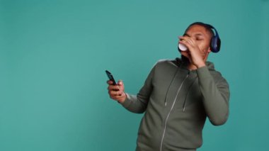 Kaygısız bir adam enerjik müzik dinliyor, ritmi abartıyor, boş zamanların tadını çıkarıyor, kahve içiyor. Öforik insan kulaklık takıyor, dans hareketleri yapıyor, stüdyo arka planında izole edilmiş, kamera B