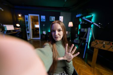 Genç içerik yaratıcısının POV 'u onu izleyen abonelere oda turu yapmak için cep telefonunu kullanıyor. Genç şovmen hayranlarına video sunumu yapıyor. Selfie çubuğuyla telefonla kayıt yapıyor.