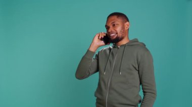 Adam telefon görüşmesinde arkadaşlarıyla konuşmaktan zevk alıyor. Akıllı telefon kullanıyor. Stüdyo arka planında izole edilmiş. Telefon görüşmesi sırasında arkadaşlarla sohbet etmek, yetişmek, kamera B