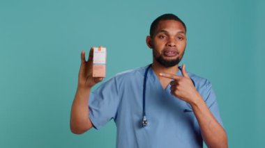 Spf50 güneş kremi kullanan hemşirelerin portresi, hastalara tavsiye veriyor, stüdyo arka planında izole edilmiş. Sağlık uzmanı insanları ultraviyole güneş koruması ve kamera A kullanmaya teşvik ediyor.