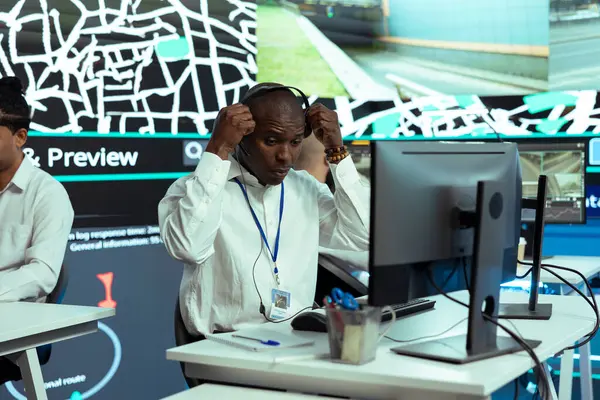 stock image African american employee monitoring express delivery service activity through urban traffic, following couriers via gps coordinates on satellite map. Dispatch operator helps with cargo shipment.