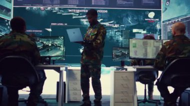 Askeri çavuş, uydu dünya haritasındaki düşman gemilerini hedef alıyor. Askeri güç üssü izleme odasından çalışıyor. Subay savunma taktiklerini bir tablette, komuta merkezinde öğreniyor. Kamera B.