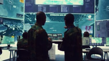 İstihbarat analistleri büyük veri analizini denetliyor ve koordine ediyor. Saha birliklerine yardım etmek için taktik bilgiler işliyorlar. Memurlar gerçek zamanlı savaş bilgilerini izliyorlar. Kamera B.